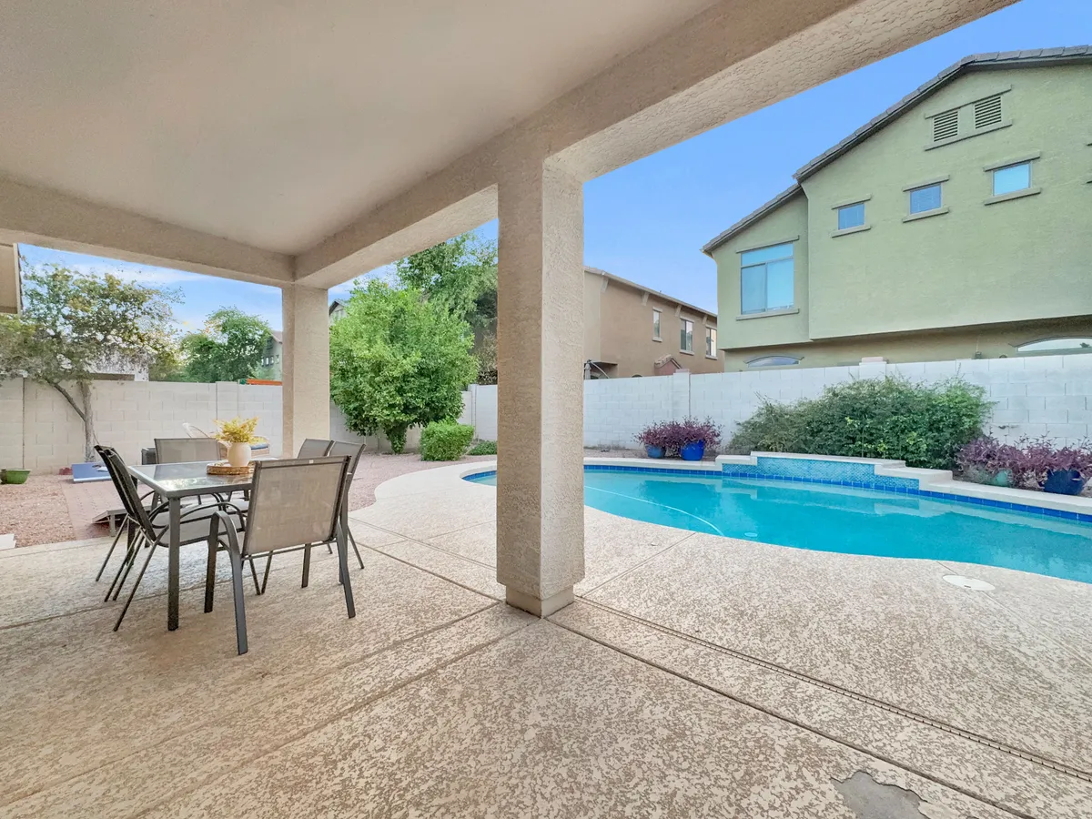 A view of the swimming pool paired with an outdoor dining table and a landscaped garden. The setup encourages both swimming and al fresco meals, with the garden adding a touch of natural beauty and privacy.