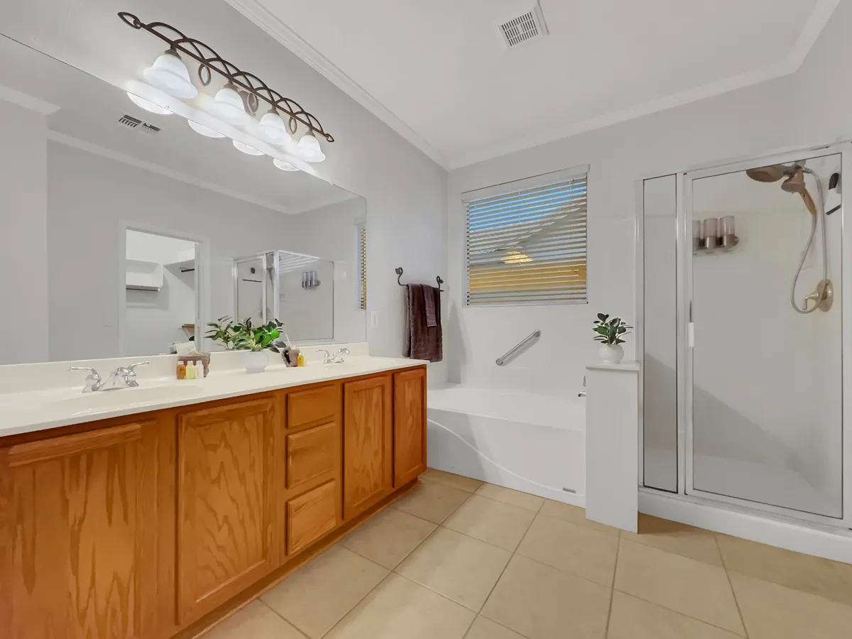 A modern bathroom with a vanity and sink, bathtub, shower enclosure, and a mirrored wall. The space feels calm and serene, equipped for both quick showers and relaxing baths.